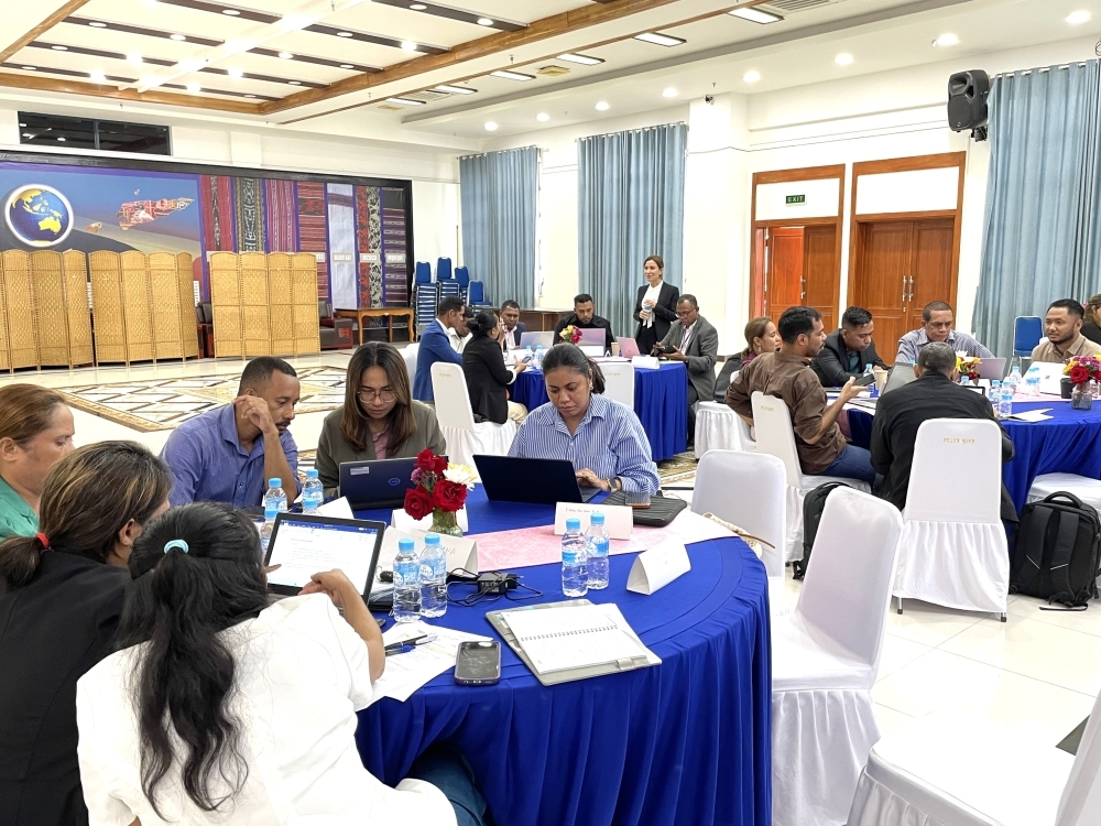 3つのテーブルがあり、各テーブルにつき6人程度の研修員が共同作業をしている。